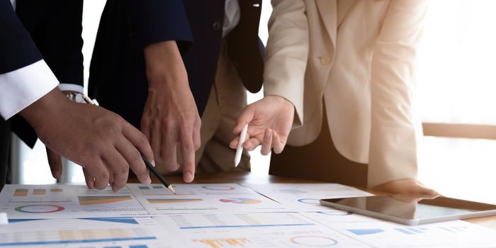 Team business people hand pointing at business document during discussion at meeting..