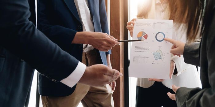 Business people hand pointing at business document during discussion at meeting..