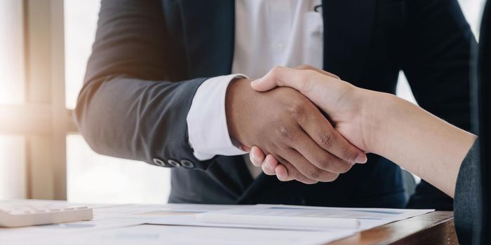 Two confident business man shaking hands during a meeting in the office, success, dealing, greeting and partner concept..