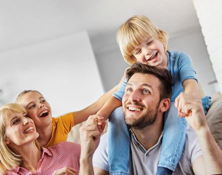 Family having fun playing on sofa at home