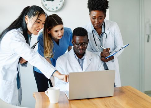 portrait of a doctors and nurses with laptop sitting by desk on their office