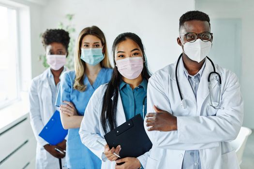 Portrait of a group of happy doctors and nurses wearing masks of diversity race in hospital
