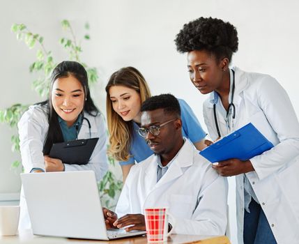 portrait of a doctors and nurses with laptop sitting by desk on their office