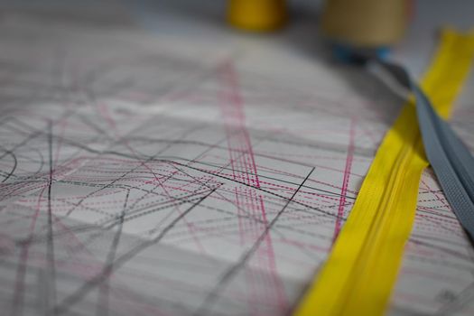 Close-up view of a paper sheet with garment blanks drawn in various sizes. Tailor's workshop during selection of tailor's blanks.