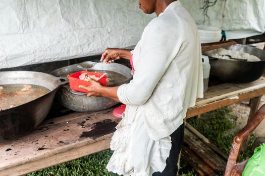 Unrecognizable indigenous woman cooking in her humble home on the Caribbean coast of Nicaragua, Central America