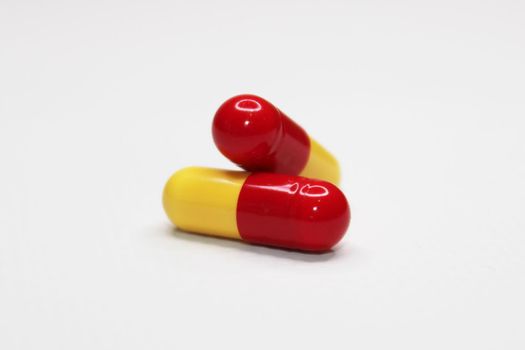 Two medicine capsules close-up on a light background. Health care concept.