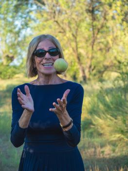 elegant lady picking plums and peaches in a farm during summer