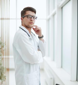 Portrait of young, doctor sitting in medical office