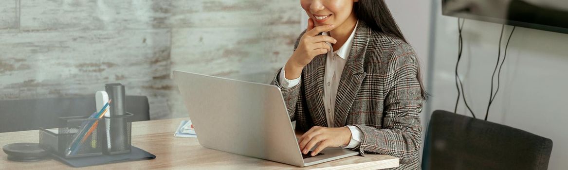 Smiling asian woman working laptop sitting in meeting room in office. High quality photo