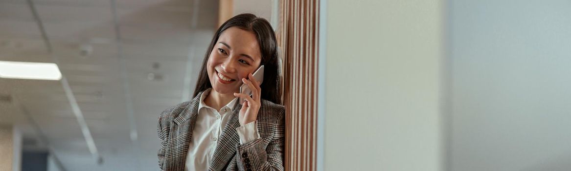 Asian business woman talking phone with client and smile. High quality photo