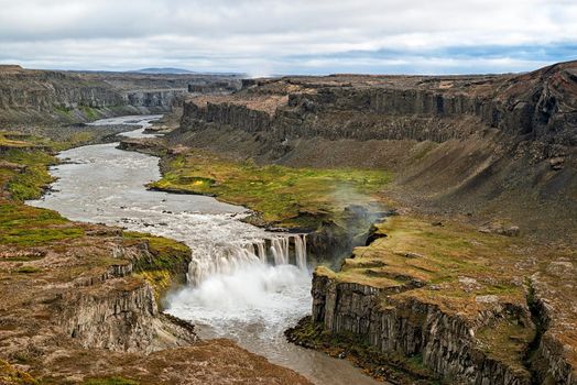 View of canyon and waterfall Hafragilsfoss seen from above in a cloudy day, Iceland