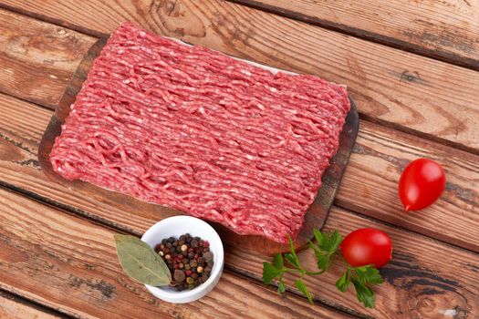 Fresh pork and beef minced meat on a wooden background.