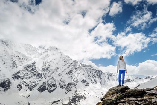 Mountains view. Blonde girl in the mountains.