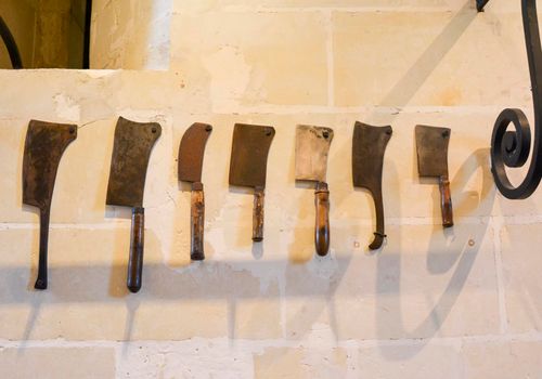 Vintage Butcher meat cleavers on a stone wall in Chenonceau castle France