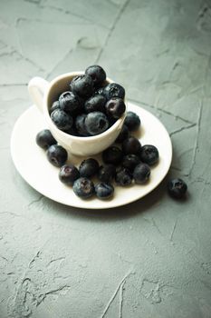 Ripe organic bilberries on dark wooden table with copyspace as a organic food concept