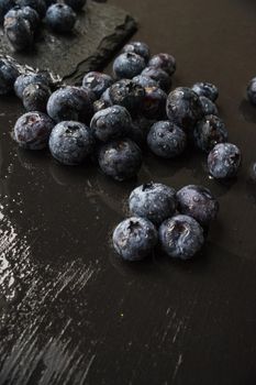 Ripe organic bilberries on dark wooden table with copyspace as a organic food concept