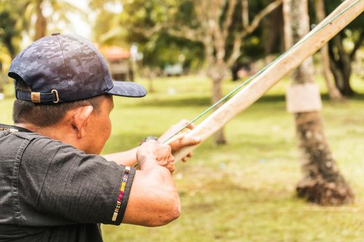 Indigenous older adult aiming at a target with his bow and arrow in the northern caribbean of Nicaragua