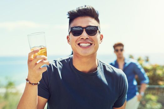 My face just says it all, Im beyond happy. Portrait of a handsome young man raising up his glass for a toast while relaxing outdoors with his friends