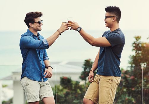 Heres to a lifetime of friendship buddy. two handsome young men having drinks and relaxing outdoors while on holiday