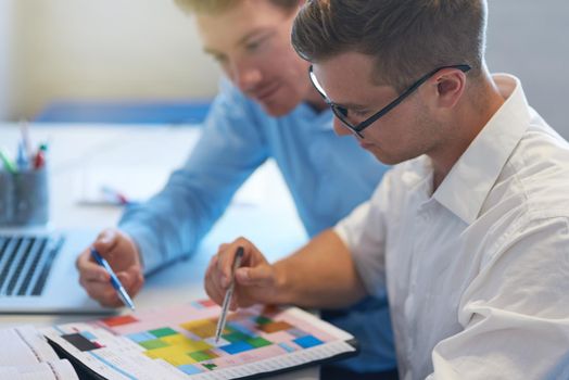 Planning our schedule for this busy month. two handsome young businessmen working together in their office