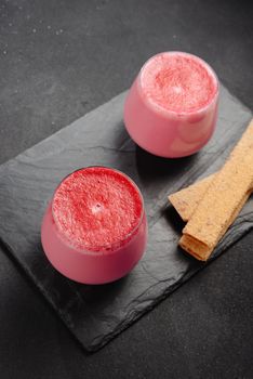 A cup of hot beet coffee latte on a light wooden background. A trendy, healthy drink.