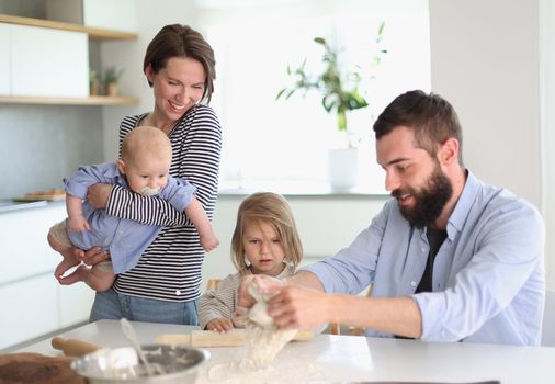 Young family with daughter and son in the kitchen