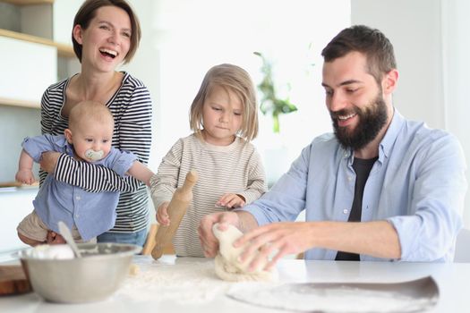 Young family with daughter and son in the kitchen