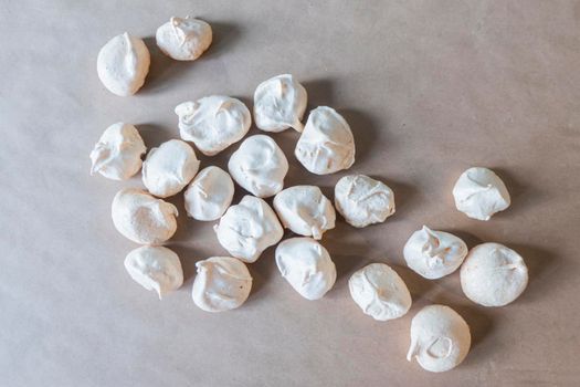 Homemade french milk-colored meringues on crumpled craft paper. flatley composition: delicious homemade meringues on craft paper