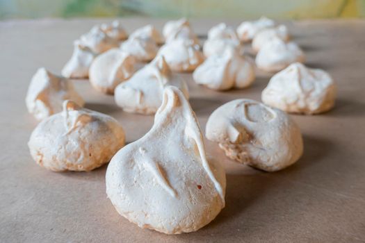 Homemade french milk-colored meringues on crumpled craft paper. flatley composition: delicious homemade meringues on craft paper