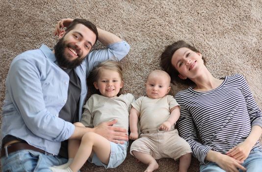 happy family mother father and kids at home. laying