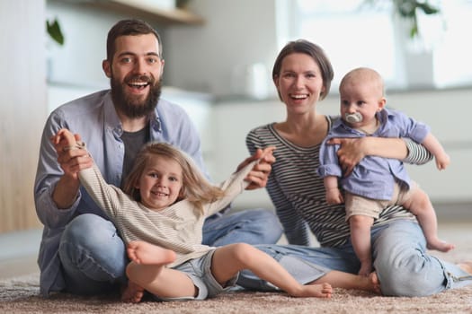 Happy parents playing with children in the kitchen