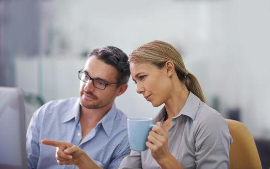 Professional business people working together on a computer, doing quality assurance and looking at information. A corporate man and woman thinking of ideas and analyzing investment statistics.