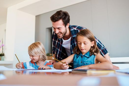 Picture perfect. a young father helping his two small children with their homework at home