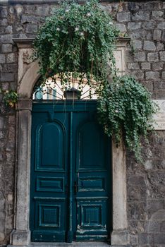 Ancient wooden door in old stone castle wall. Front Door and exterior of a beautiful old building on a street in an Europe town.