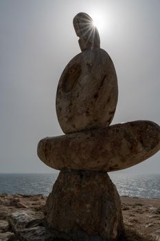 Sculpture symbol made of large pebbles against the blue sky.