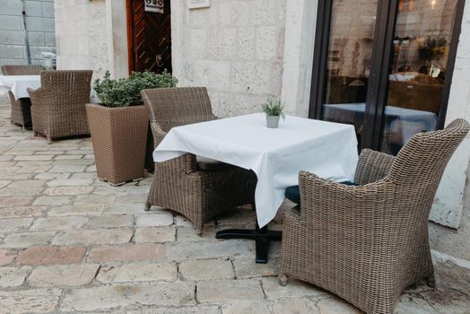 Morning street empty outdoor cafe with traditional wooden chairs waiting for guests or tourists. Cafe terrace in small European city. Summer cafe, empty tables in outdoors cafe in Europe, Coffeeshop, Cafe on the street, outdoors