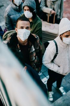 People traveling during covid travel restrictions are waiting for coronavirus testing. Portrait of tourists or travelers walking on stairs in a public airport during a lockdown due to virus outbreak.