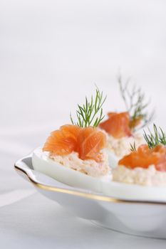 Appetizer of stuffed eggs stuffed with salmon pate and yolks with salmon slices. Holiday table idea

