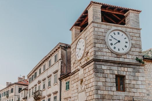 The clock tower on the army square at the entrance gate in the medieval city of Kotor. Evening view. Kotor, Montenegro