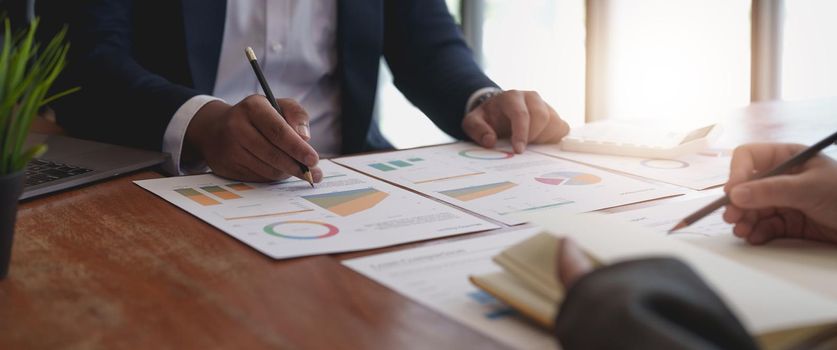 Smart businessman and businesswoman talking discussion in group meeting at office table in a modern office interior. Business collaboration strategic planning and brainstorming of coworkers