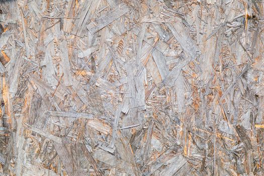 OSB material texture is a board made from recycled pressed wood shavings. Chipboard from large wood waste. Close-up.
