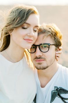 Young woman hugs a man sitting in his arms. Portrait. High quality photo