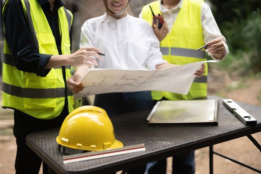 Construction engineers discussion with architects at construction or building site.