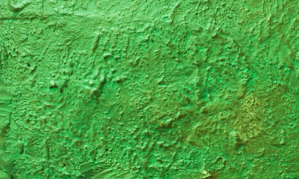 Not evenly plastered green wall. Abstract background from a wall with old green paint.