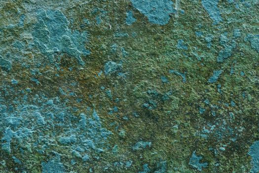 Moldy blue wall with damaged paint. Stone structure background close-up.