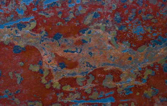 Rough rusty metal surface. Texture from an old damaged red wall with blue spots.