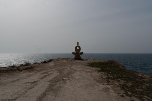 Sculpture symbol made of large pebbles against the blue sky.