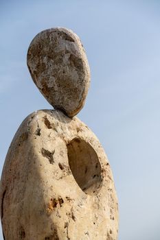 Sculpture symbol made of large pebbles against the blue sky.