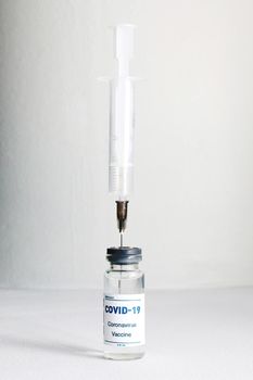 Syringe inserted in the vial with the Covid-19 Vaccine.Medical concept.
