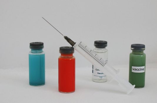 White, red, green and blue ampoule with vaccine.